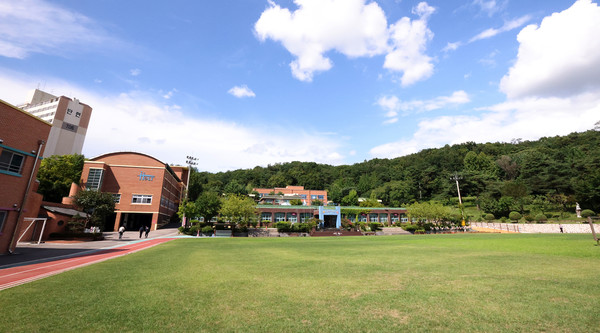  홀트학교 전경. 잔디가 푸르른 운동장과 녹음짙은 산은 교육환경으로 더할나위 없이 좋다.