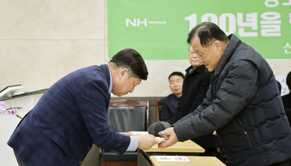 홍성규 조합장이 노인정 회장에게 상품권을 전달하고 있다.