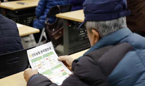  이날 전달식 참석자가 하나로마트 이용권을 사용할 수 있는 신도농협 본지점 안내문을 살펴보고 있다.