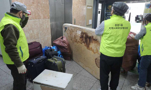 탄현1동 지역사회보장협의체 위원들이 폐기물을 운반하고 있다.