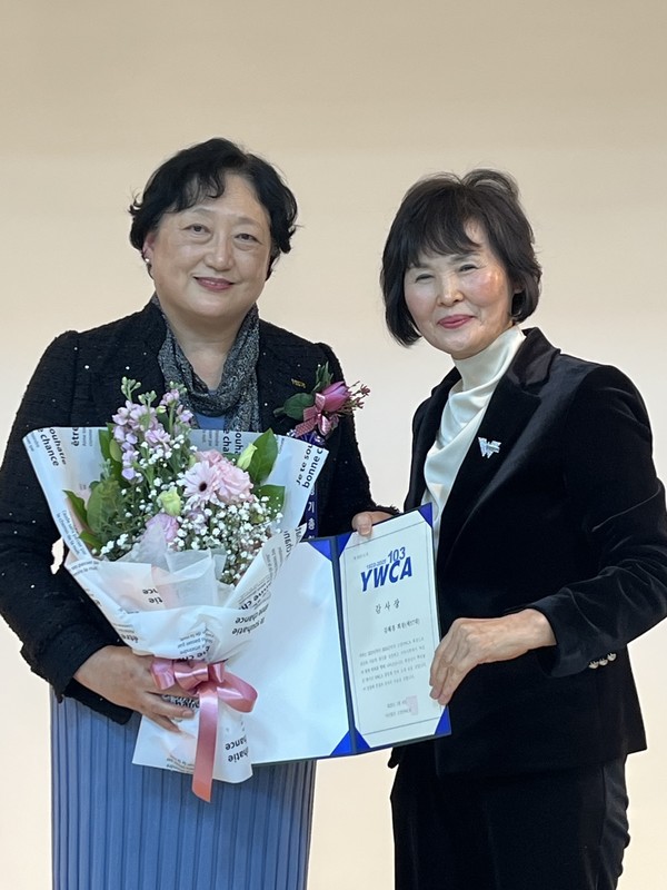 꽃다발과 감사장을 주고받은 김혜경 이임 회장(왼쪽)과 김용주 신임 회장(오른쪽).