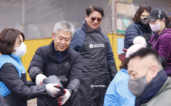 고진경 강원도민회 고양특례시지회장(왼쪽 두 번째)과 황대일 예비역 육군본부 참모차장 중장(세 번째)이 연탄봉사에서 참여자들과 밝은 모습으로 나눔을 실천하고 있다.