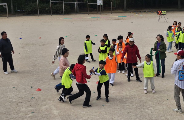 체육대회 사제동행 게임, 넘어진 학생과 함께 뛰는 선생님들. [사진제공=목암초등학교]