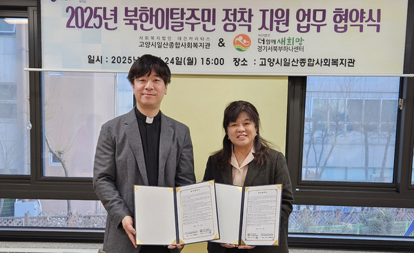 업무 협약식에서 고양시일산종합사회복지관 최찬영 관장(왼쪽)과 경기서북부하나센터 김영숙 센터장(오른쪽)이 업무 협약서를 들고 기념 촬영을 하고 있다.