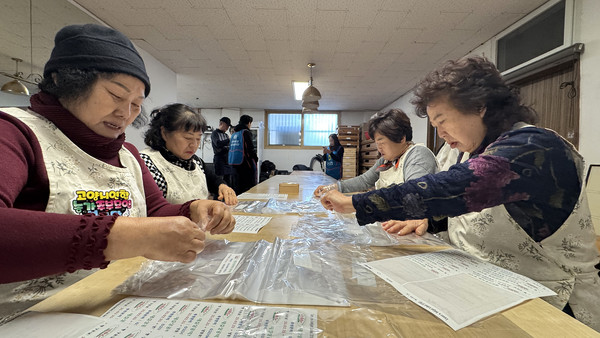 식빵을 포장하기 위해 스티커를 붙이기 작업을 하는 농가주모 회장단.