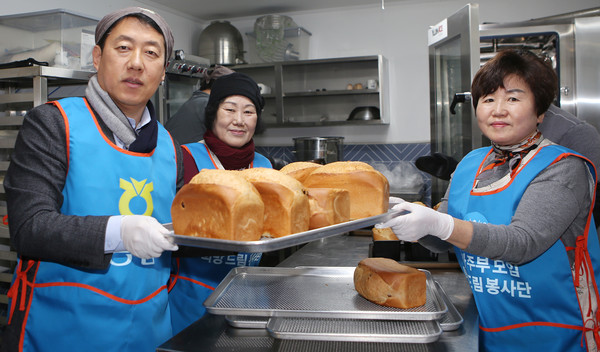 막 나온 식빵을 들고 포장대로 옮기는 오영석 농협 고양시지부장(왼쪽)과 최다남 농가주모 연합회장(가운데),  양혜경 송포농협 온가주모 회장(오른쪽).