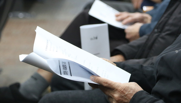 설명회 자료를 꼼꼼하게 살펴보는 조합원들.