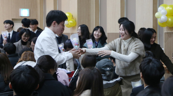 학생들에게 입학축하 꽃을 전달하는 홀트학교 교사