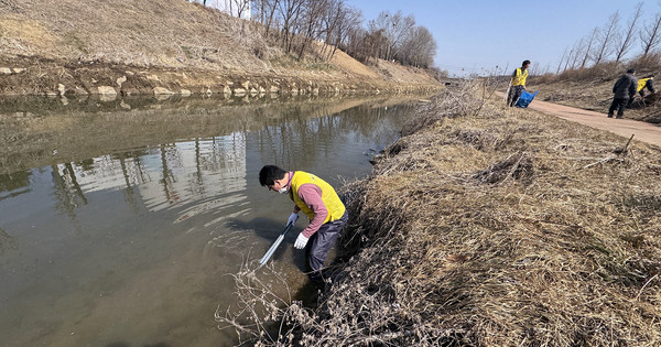 도촌천에 버려진 쓰레기를 줍는 참여자.