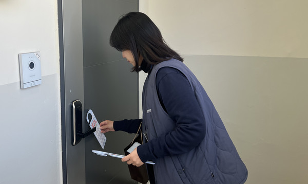  ‘찾아가는 향동복지관’ 문고리 홍보를 하는 관계자.