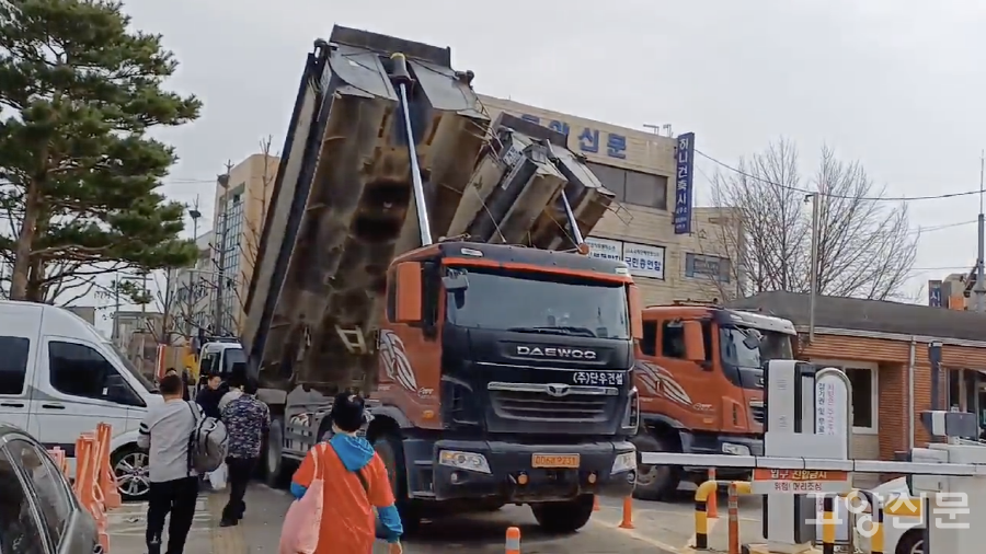 고양시청 정문을 막은 덤프트럭 옆으로 시민들이 오가고 있다.