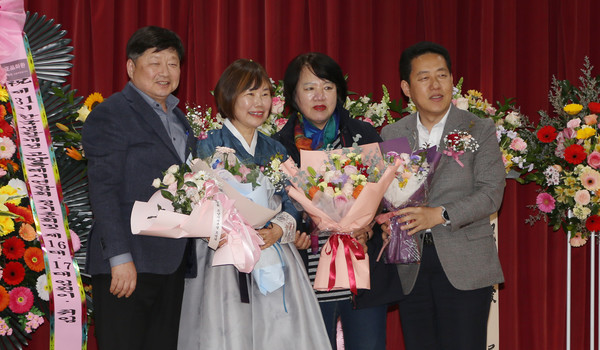 김정임 신임 회장(왼쪽 두 번째)에게 참석자들이 꽃다발을 전달하며 함께 기념 사진을 찍고 있다.