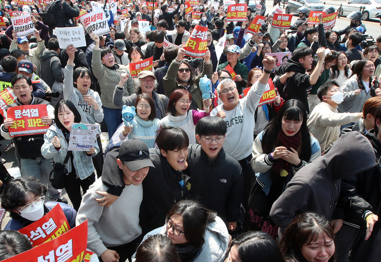12·3 비상계엄 123일 만에 윤석열 대통령의 파면이 확정되는 순간. 4일 서울 용산구 대통령관저 인근에서 헌법재판소의 탄핵선고를 생중계로 지켜보던 시민들이 주먹을 불끈 쥐며 기뻐하고 있다. [사진제공=이정민 오마이뉴스 기자]