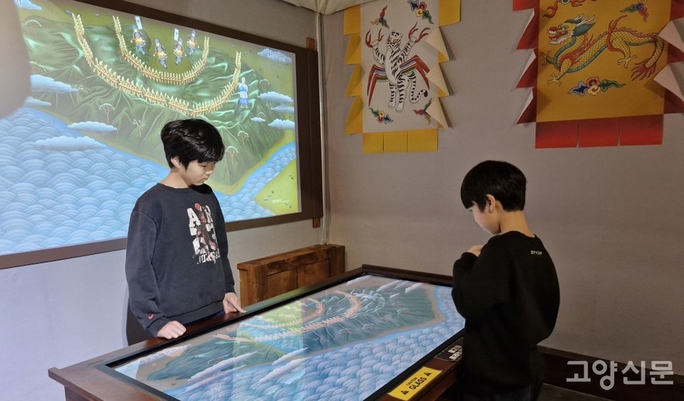 행주대첩을 소재로 한 참여형 시물레이션 게임을 즐기며 역사를 공부하는 어린이들.