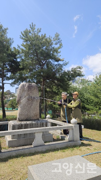 물을 뿌려가며 밥할머니 석상에 묻어있는 오염물질을 제거하는 모습