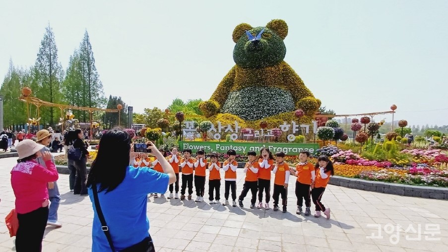 올해 꽃박람회의 상징조형물인 '황금빛 판다' 앞에서 사진을 찍는 꼬마들. 