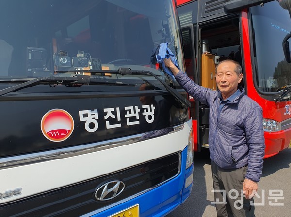 이종대 전무가 주차장에 새워진 버스의 앞 유리창을 닦고 있다.