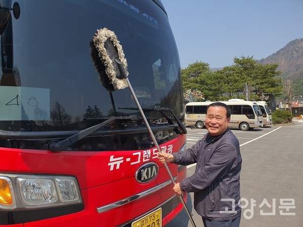 허정길 이사가 주차장에 새워진 버스의 앞 유리창을 닦고 있다.