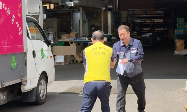 이동균 코스탈(주) 이사(오른쪽)가 사랑의 징검다리 봉사단을 반갑게 맞이하고 있다.