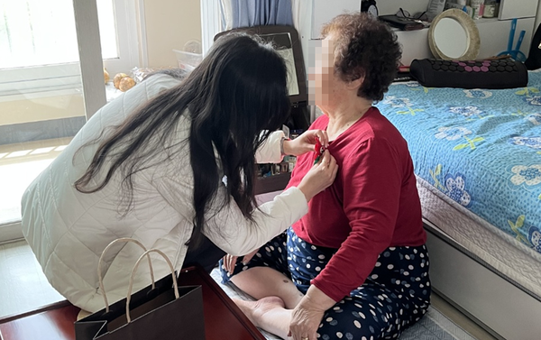 향동종합사회복지관의 한 관계자가 어버이날 맞이 카네이션을 전달하고 있다.