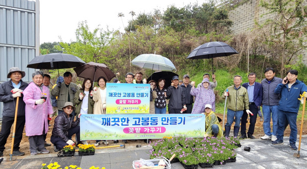 께끗한 고봉동 만들기에 참여한 주민들. 비가 오는 가운데도 꽃밭가꾸기를 즐겁게 진행했다.