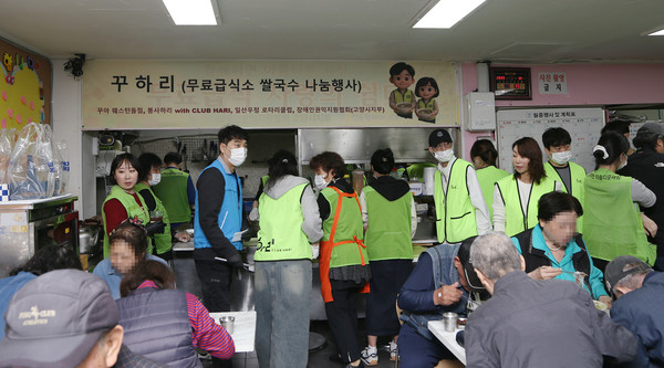  봉사자들이 지역주민들의 식탁을 보며 부족한것이 없는지 확인을 하고 있다.