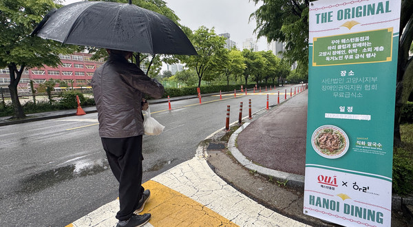 한 주민이 식사 후 급식소에서 준비한 과일과 떡을 들고 집으로 향하고 있다.