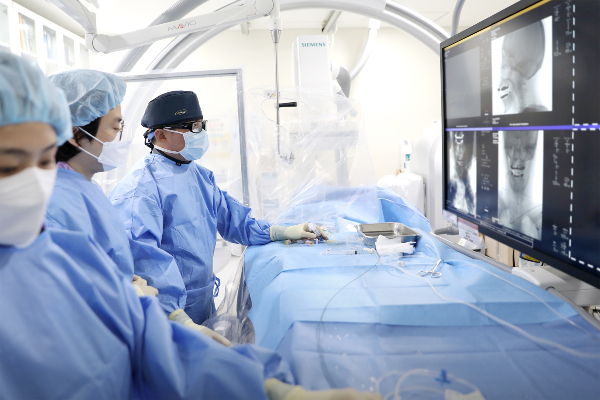 일산백병원 구해원 교수가 뇌동맥류 환자에게 코일색전술을 시행하고 있는 모습. 특수 영상장비를 활용해 뇌혈관 내 미세도관을 삽입한 뒤, 동맥류 내부에 백금 코일을 삽입해 혈류를 차단하는 고난도 시술이다. [사진제공 = 일산백병원]