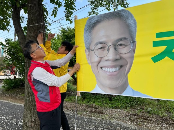 노동당 고양파주지역위 김동성 위원장과 민주노동당 파주지역위 김찬우 위원장이 함께 거리 현수막을 걸고 있다.