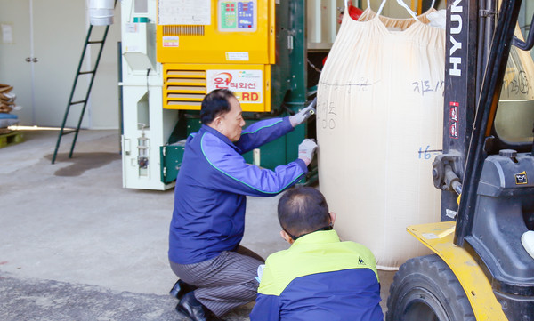 추수철에도 농민들의 결실을 함께하며 고마움을 전한다. 벼가 담겨있는 톤백에 숫자를 쓰는 장 조합장.