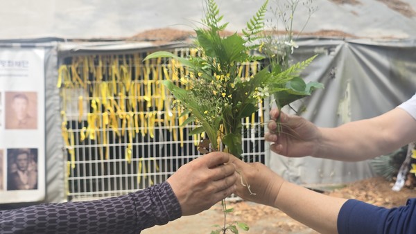 마을숲 탐사에 나선 시민들이 꽃다발을 만들어 금정굴 희생자들을 추모하고 있다.