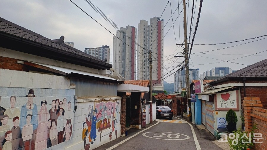 담장과 대문에 알록달록 벽화가 그려져 있는 의주로 골목길. 멀리 우뚝 솟아있는 주상복합빌딩과 기묘한 대비를 이루고 있다. 