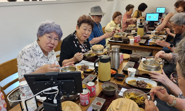 식사를 하며 즐거워하는 어르신들.