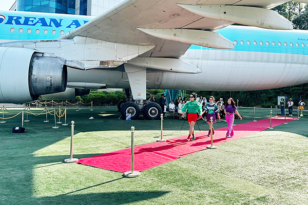 한국항공대가 교내 전시 항공기인 A300-600 앞에서 진행된 ‘2025 상반기 고양시 신중년 대학 특화과정-파워 이미지메이킹 스타일링 아카데미’패션쇼에서 수료생들이 워킹을 선보였다. [사진제공 = 한국항공대학교]