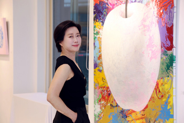 유미아 작가가 작품 앞에서 포즈를 취하고 있다.