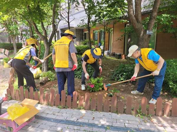 봉사단이 주민 이용이 많은 곳에 꽃을 심고 있다.
