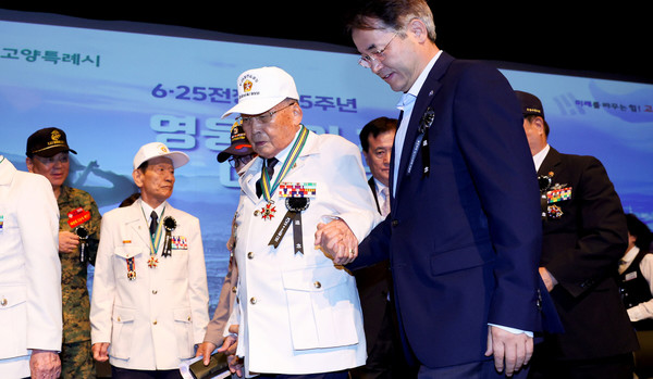 표창을 받은 국가유공자와 함께 손을 잡고 걸어가고 있는 이동환 고양시장.