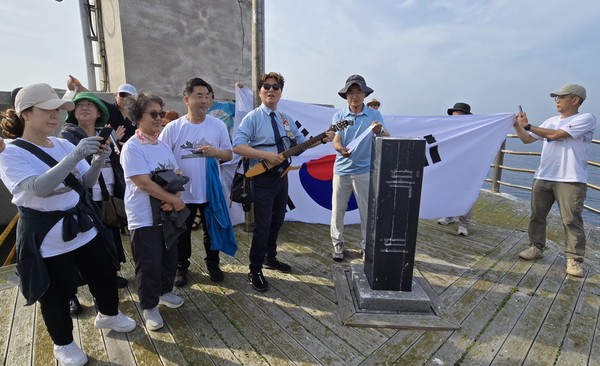탐사대원들이 동도 망양대에서 가수 백자와 함께 <홀로 아리랑〉을 부르고 있다