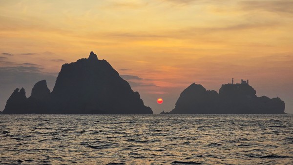 범선에서 맞이한 독도 일출. 동도와 서도 사이로 해가 솟아오르고 있다.