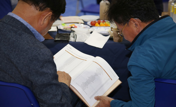 책을 보며 이야기를 나누는 일산초등학교 동문들.