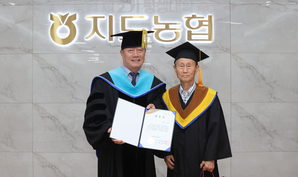 지도농협 장순복 조합장(왼쪽)이 평생대학 수료생에게 열정상을 전달했다.