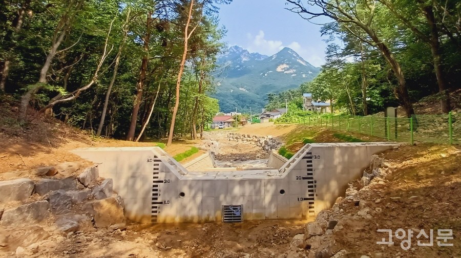 지축동 노고산 아랫자락 매미골 계곡 하부에 신규 설치된 사방댐. 아래쪽 마을 방향을 바라본 사진으로, 건너편 북한산 봉우리가 보인다. 