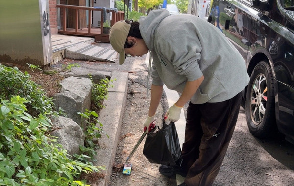  프로그램에 참여한  자원봉사자가 환경활동을 하고 있다.