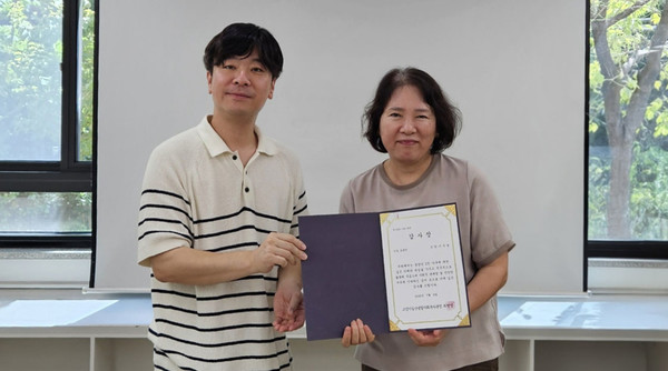 최찬영 일산종합사회복지관장이 ‘중장년-이음’자원봉사자에게 감사장을 전달하고 있다.