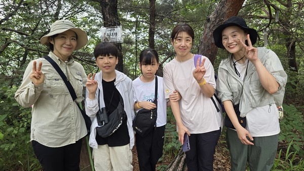  옥녀봉 정상에서 기념사진을 찍고 있는 김윤선(왼쪽) 숲해설가와 마을숲 탐방객들. 숲내초등학생 박선우(왼쪽에서 두 번째)군은 뻐꾸기 소리 흉내를 잘 내 탐방객들로부터 인기를 독차지했다.