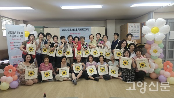 자신만의 에코백에 그림을 그리고 단체사진 촬영하는 화정2동 경로당 어르신들.