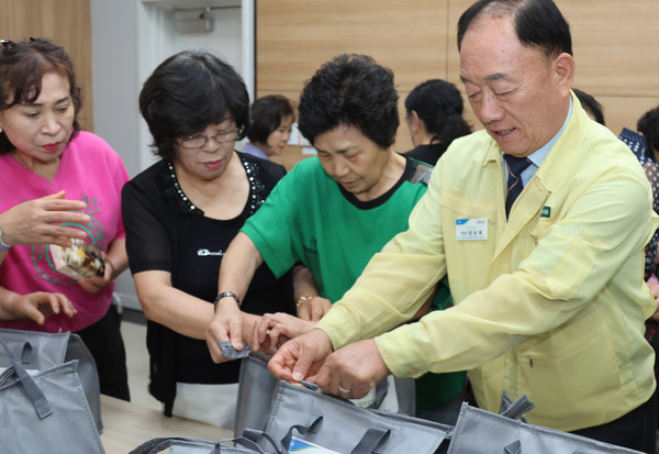 장순복 지도농협 조합장과 고향주부모임 회원들이 전달품을 포장하고 있다.