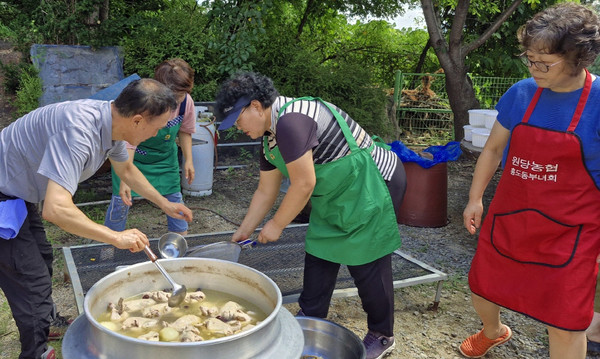 이용진 흥도동장과 새마을부녀회 지도자협의회 회원들이 삼계탕을 만들고 있다.