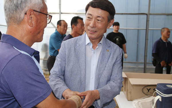  트랙터 무상 점검일에 조합원의 손을 꼭잡고 이야기를 나누는 이창림 조합장.