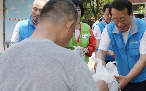 유완식 고양축산농협 조합장이 지역민에게 삼계탕 꾸러미를 전달하고 있다.
